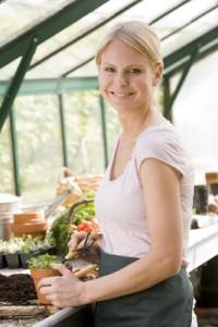 Woman Growing Vegetables at Home in an Urban Greenhouse Garden